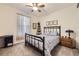 Bedroom with a wrought iron bed, ceiling fan, and natural light from the window at 15211 Quince St, Thornton, CO 80602