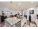 Open kitchen with island, granite counters, white cabinets, and views into the living area at 15211 Quince St, Thornton, CO 80602