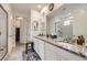 Main bathroom featuring double sinks, granite counters, and a large mirror at 15211 Quince St, Thornton, CO 80602