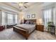 Main bedroom with tray ceiling, bay window, and neutral decor at 15211 Quince St, Thornton, CO 80602