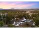 Aerial view of a gray cabin nestled among pine trees with snow and mountains in the background at 2859 Cagle Dr, Larkspur, CO 80118