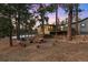 Inviting exterior view of a gray cabin with a deck and outdoor seating under a colorful sky at 2859 Cagle Dr, Larkspur, CO 80118