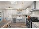 Bright kitchen with stainless steel appliances, white cabinets and a wooden kitchen island at 2859 Cagle Dr, Larkspur, CO 80118