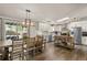 Open-concept kitchen and dining area with modern stainless steel appliances, white cabinets, and wood floors at 2859 Cagle Dr, Larkspur, CO 80118