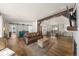 Open-concept living room and dining room with hardwood floors, wood beam, and barn doors at 2859 Cagle Dr, Larkspur, CO 80118