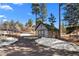 Backyard shed featuring a long driveway and partially snow covered lot at 2859 Cagle Dr, Larkspur, CO 80118