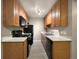 A galley kitchen showcases wood cabinets, a black stove and refrigerator, and a light countertop at 10792 E Exposition Ave # 154, Aurora, CO 80012