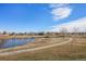 Scenic park view featuring a paved walking path winding alongside a tranquil pond and lush green space at 10792 E Exposition Ave # 154, Aurora, CO 80012