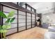 Spacious living room with sliding panel doors, exposed ceiling, hardwood floor, and dark trim at 2501 15Th St # 2C, Denver, CO 80211