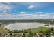 Scenic aerial view of a lake surrounded by lush greenery under a partly cloudy blue sky at 1820 Newland Ct # 310, Lakewood, CO 80214