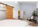 Airy bedroom with vaulted ceiling, decorative plants, and a sliding wooden door to closet and access to living space at 1820 Newland Ct # 310, Lakewood, CO 80214