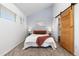 Serene bedroom with queen bed, stylish rug, and sliding wooden door leading to closet at 1820 Newland Ct # 310, Lakewood, CO 80214