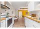 Modern kitchen leading to dining area with stainless steel appliances, wood counters and sleek vent hood at 1820 Newland Ct # 310, Lakewood, CO 80214