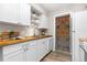 Bright kitchen features white cabinets, light wood countertops and flooring, open shelving, and beaded door curtain at 1820 Newland Ct # 310, Lakewood, CO 80214