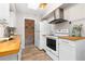 Efficient kitchen with white cabinetry, butcher block counters, and stainless steel appliances at 1820 Newland Ct # 310, Lakewood, CO 80214