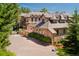 Grand brick home with a circular driveway and meticulously landscaped grounds at 77 Comstock Pl, Castle Rock, CO 80108