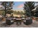 Stone patio boasts a cozy fire pit with comfortable wicker seating, perfect for outdoor gatherings at 77 Comstock Pl, Castle Rock, CO 80108