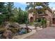 Elegant home with a stone water feature and lush landscaping creates a serene and inviting entrance at 77 Comstock Pl, Castle Rock, CO 80108