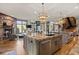 Open concept kitchen with island seating, stainless steel appliances, and brick accents at 77 Comstock Pl, Castle Rock, CO 80108