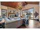 Inviting living room with stone fireplace, wood-beam ceiling, antler chandelier, and a large window view at 77 Comstock Pl, Castle Rock, CO 80108