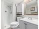 Bathroom features a white vanity, toilet, medicine cabinet, and shower stall with tiled walls at 3134 S Fairplay St, Aurora, CO 80014