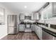 Updated kitchen featuring stainless steel appliances, granite countertops, and grey cabinets at 3134 S Fairplay St, Aurora, CO 80014