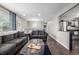 Open living room with hardwood floors, two sofas, and an adjacent, updated kitchen at 3134 S Fairplay St, Aurora, CO 80014