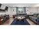 Comfortable living room with dark wood floors, plush furniture, and bright window lighting at 3134 S Fairplay St, Aurora, CO 80014