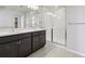 Modern bathroom with dual sinks and a walk-in shower with glass enclosure at 7241 Goldbloom Ln, Littleton, CO 80125