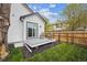 Backyard with gray deck, chairs, grass area, and nice landscaping at 22 S Harlan St, Lakewood, CO 80226