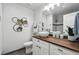 Bathroom features a wood vanity top, stylish floral decor, and ample lighting at 22 S Harlan St, Lakewood, CO 80226