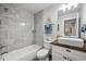 A renovated bathroom featuring modern fixtures, stylish tiling, and wood accents at 22 S Harlan St, Lakewood, CO 80226