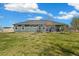 Exterior of the home with a sprawling backyard, covered patio, and well-manicured lawn at 56330 E 37Th Ct, Strasburg, CO 80136