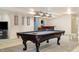 Finished basement boasts a pool table, soft lighting, and plush carpet at 56330 E 37Th Ct, Strasburg, CO 80136