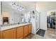 Bright bathroom with double sinks, large mirror, walk-in shower, and a closet for extra storage at 56330 E 37Th Ct, Strasburg, CO 80136