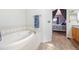 Elegant bathroom with a large soaking tub, tile accents, and an arched entrance to the main bedroom at 56330 E 37Th Ct, Strasburg, CO 80136