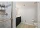 Clean bathroom featuring tiled shower with glass door, dark vanity, and modern toilet at 56330 E 37Th Ct, Strasburg, CO 80136