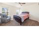 This bedroom features a ceiling fan, leather bed frame, chair, and natural light at 56330 E 37Th Ct, Strasburg, CO 80136