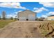 Large outbuilding on a gravel drive and two garage doors with basketball hoop at 56330 E 37Th Ct, Strasburg, CO 80136