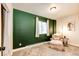 Cozy bedroom featuring a comfy chair near window and dark green accent wall at 43388 Somerset Ct, Elizabeth, CO 80107