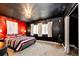 Unique bedroom with dark ceiling, bold red accent wall, and plush bedding at 43388 Somerset Ct, Elizabeth, CO 80107