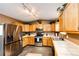 Bright kitchen with wood cabinetry, stainless steel appliances including a refrigerator, and a spacious tiled floor at 43388 Somerset Ct, Elizabeth, CO 80107