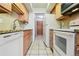 Galley kitchen with light wood cabinets, granite countertops, and stainless steel appliances at 534 E 7Th Ave # 107, Denver, CO 80203