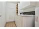 Efficient laundry room with washer, dryer, shelving, and storage cabinets at 534 E 7Th Ave # 107, Denver, CO 80203