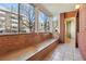 Bright sunroom with tile floors, wood bench, and large windows at 534 E 7Th Ave # 107, Denver, CO 80203