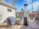 Cozy backyard patio area with stone flooring, heater, and comfortable blue cushioned seating at 5920 S Bemis St, Littleton, CO 80120