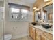 Bathroom featuring dual vessel sinks, wood-look accent wall, and natural light at 5920 S Bemis St, Littleton, CO 80120