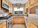 Bright kitchen with stainless steel appliances, granite countertops, and wood cabinetry at 5920 S Bemis St, Littleton, CO 80120