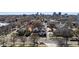 Aerial view of a residential neighborhood with mature trees and a city skyline in the distance at 1922 E 18Th Ave, Denver, CO 80206