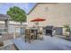 Outdoor deck area with a barrel table, chairs, grill, red umbrella, and privacy fence at 11832 Zenobia Loop, Westminster, CO 80031